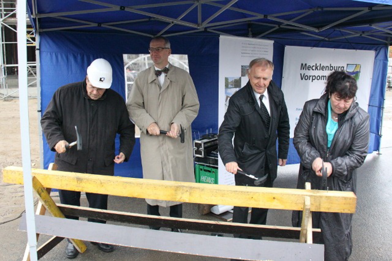 Rektor Wolfgang Schareck, Oliver Kühn (Institut für Physik), Karl-Heinz Meiwes-Broer  (Leiter des Departments Leben, Licht & Materie) und Finanzministerin Heike Polzin versenken die letzten Nägel