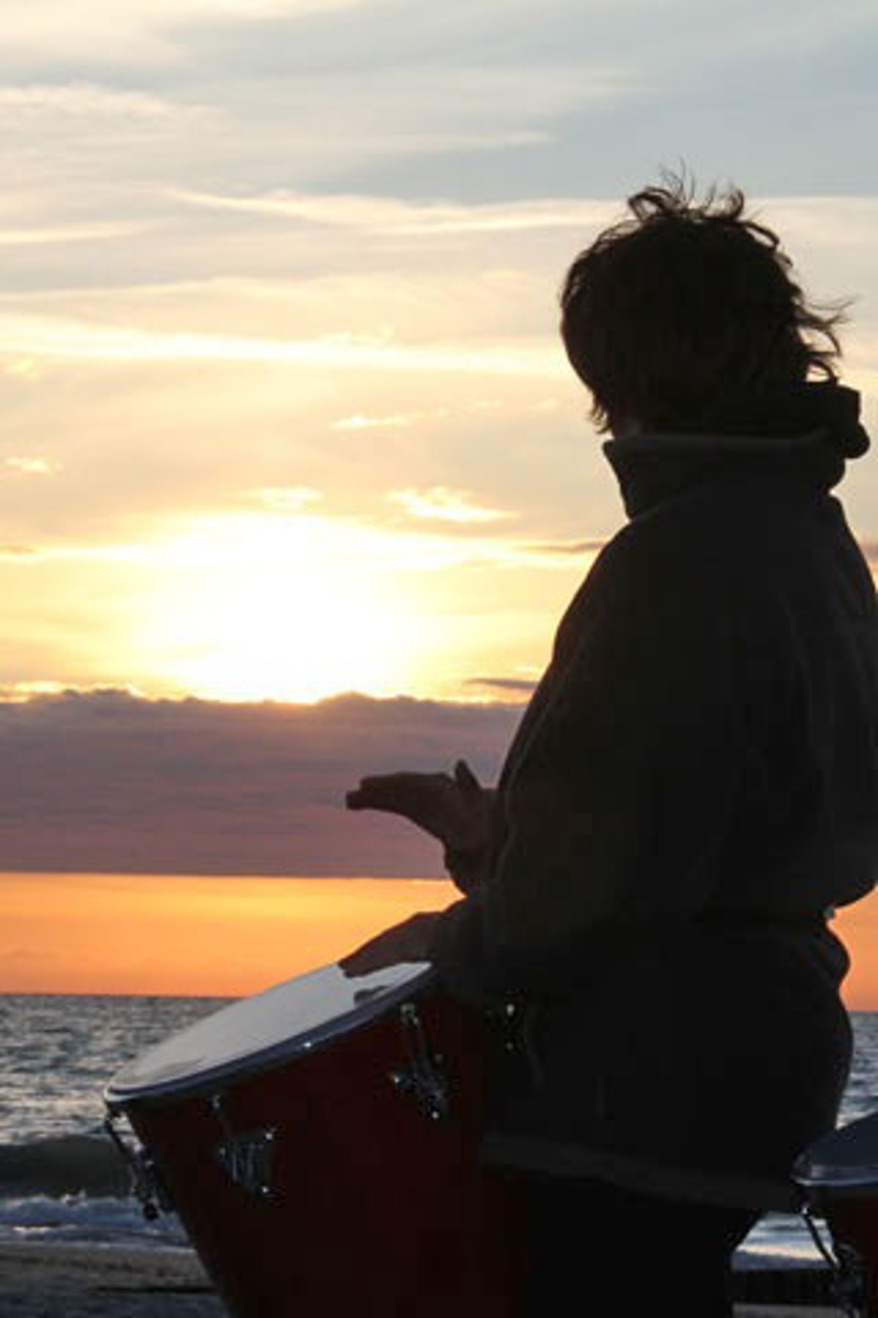 Trommlerin vor der der Kulisse des Warnemünder Sonnennuntergangs
