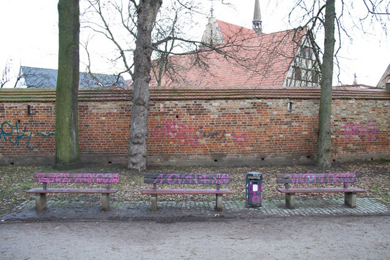 Bekritzelte Stadtmauer und Bänke