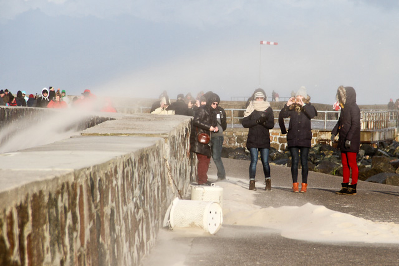 Hartgesottene "Sturmfans" auf der Westmole in Warnemünde. Hier wehte ordentlich der feine Sand in alle Poren.