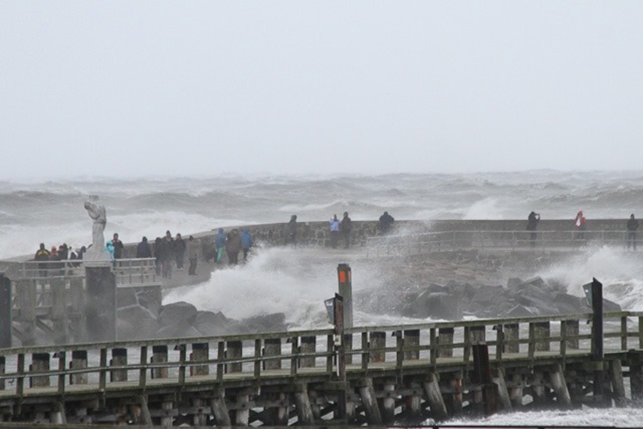 Ungemütlicher geht es bald gar nicht mehr auf den Warnemünder Molen. Trotzdem sind zahlreiche Schaulustige unterwegs.