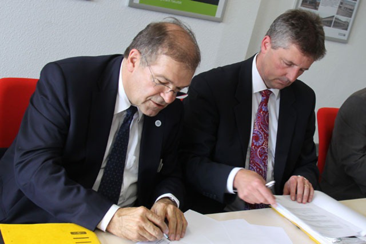 Universitätsrektor Prof. Dr. Wolfgang Schareck (links) und Christan Weiß von Rostock Business unterzeichnen den Kooperationsvertrag