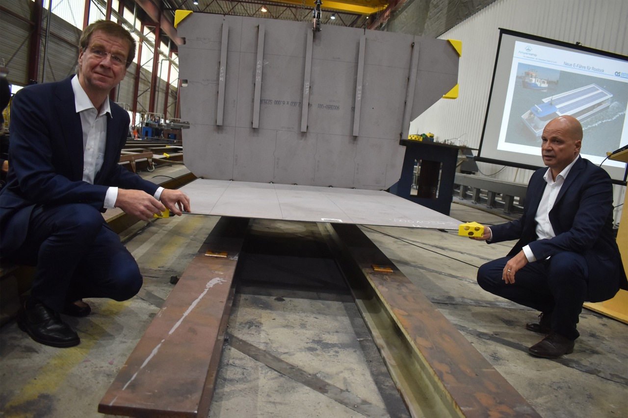 Dr. Thomas Kühmstedt, Technischer Direktor bei Ostseestaal, (links) und Rostocks Finanzsenator Dr. Chris Müller-von Wrycz Rekowski platzierten zur Kiellegung zwei Gedenkmünzen unter ein erstes Stahlbauteil der Hecksektion der Elektro-Solar-Personenfähre. (Foto: Ostseestaal)