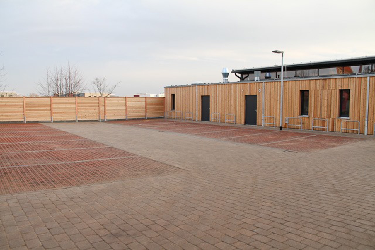 Vor dem Jugendzentrum ein Parkplatz mit Stellplätzen für 14 Autos und neun einseitig benutzbare Fahrradbügel.