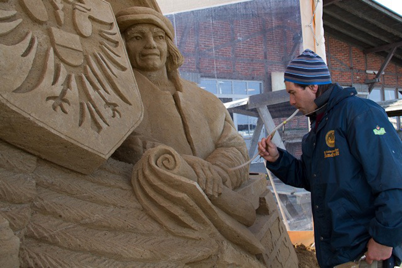 Andrey Molokov mit seiner Sandskulptur „Kaufmann der Hanse, Verbund der Hansestädte“
