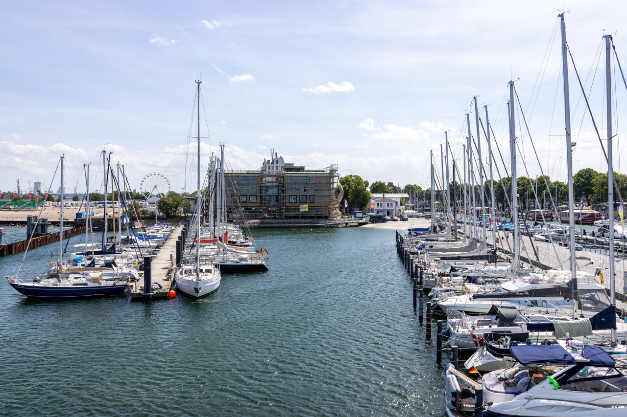 Blick auf die Südseite des Sportboothafens Warnemünde mit der im Bau befindlichen Landessportschule