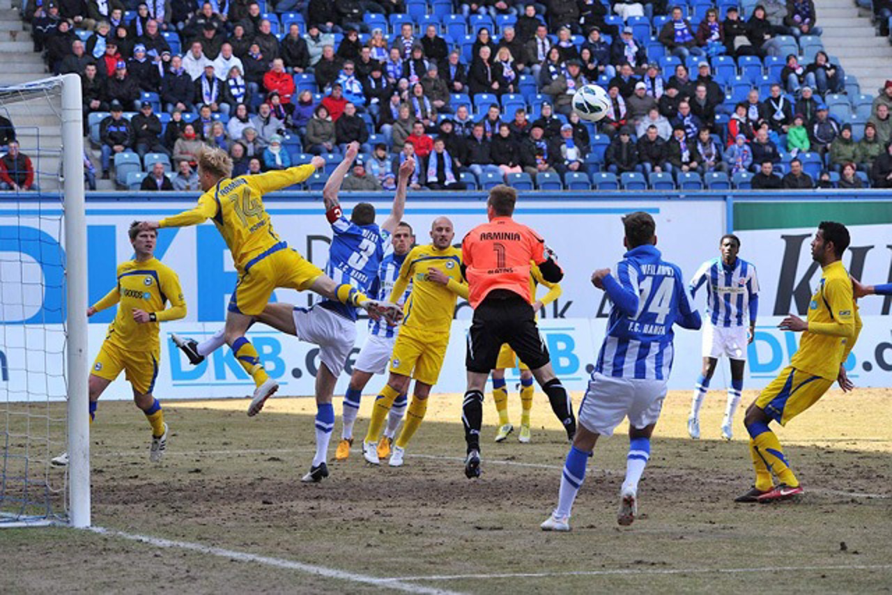 Manuel Hornig (Arminia Bielefeld) kann per Kopf vor Matthias Holst (Hansa Rostock) klären