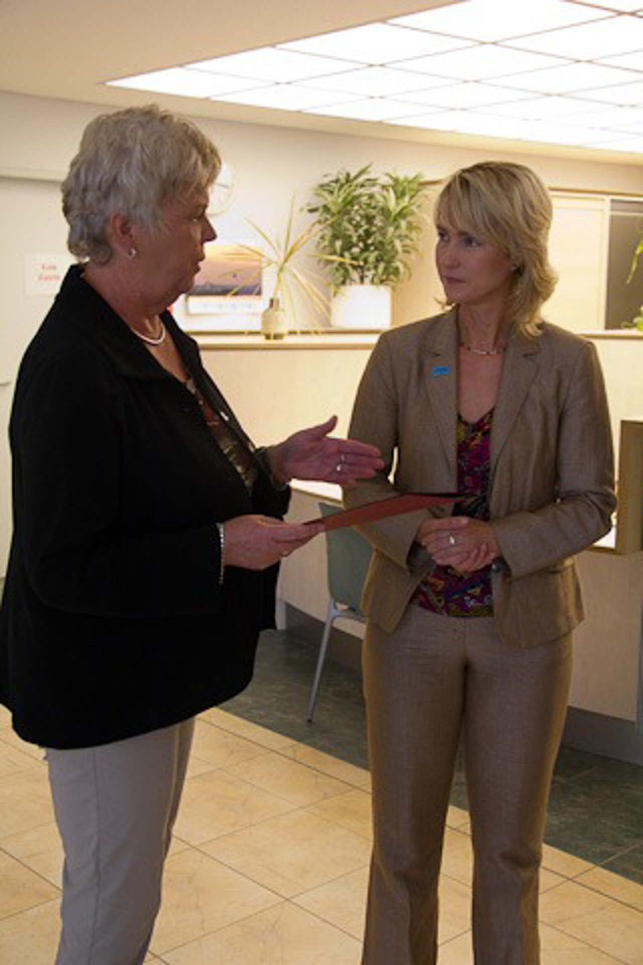 Verwaltungsdirektorin Renate Fieber (l.) nimmt den Fördermittelbescheid von Manuela Schwesig entgegen