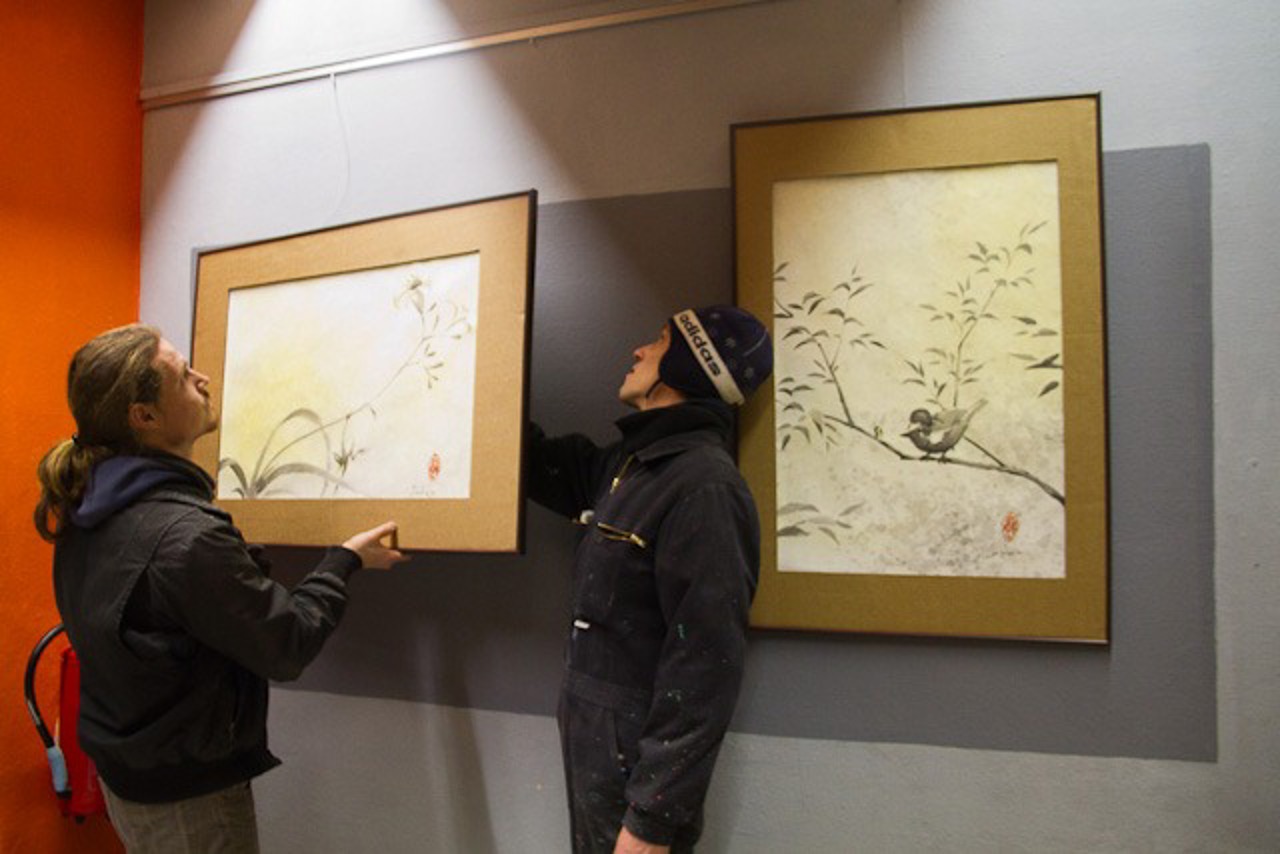 Karl Constien und Sebastian Volgmann hängen Bilder für die Space Pirates Ausstellung im PWH