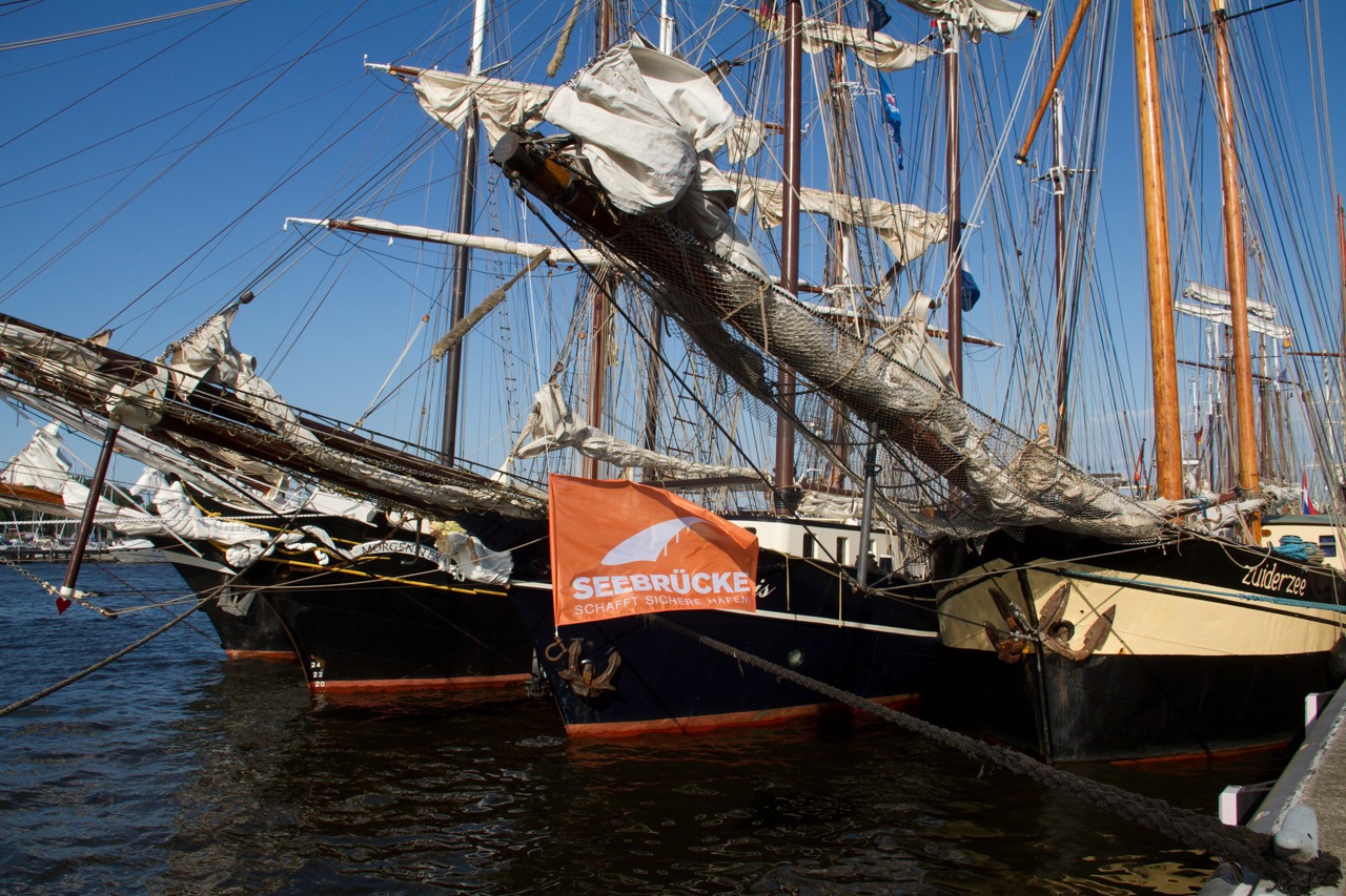 Einige Schiffe haben die orange Seebrücke gehisst als Zeichen für die Seenotrettung und gegen das Sterben auf dem Mittelmeer. Zu der Aktion hatte „Rostock hilft“ aufgerufen.