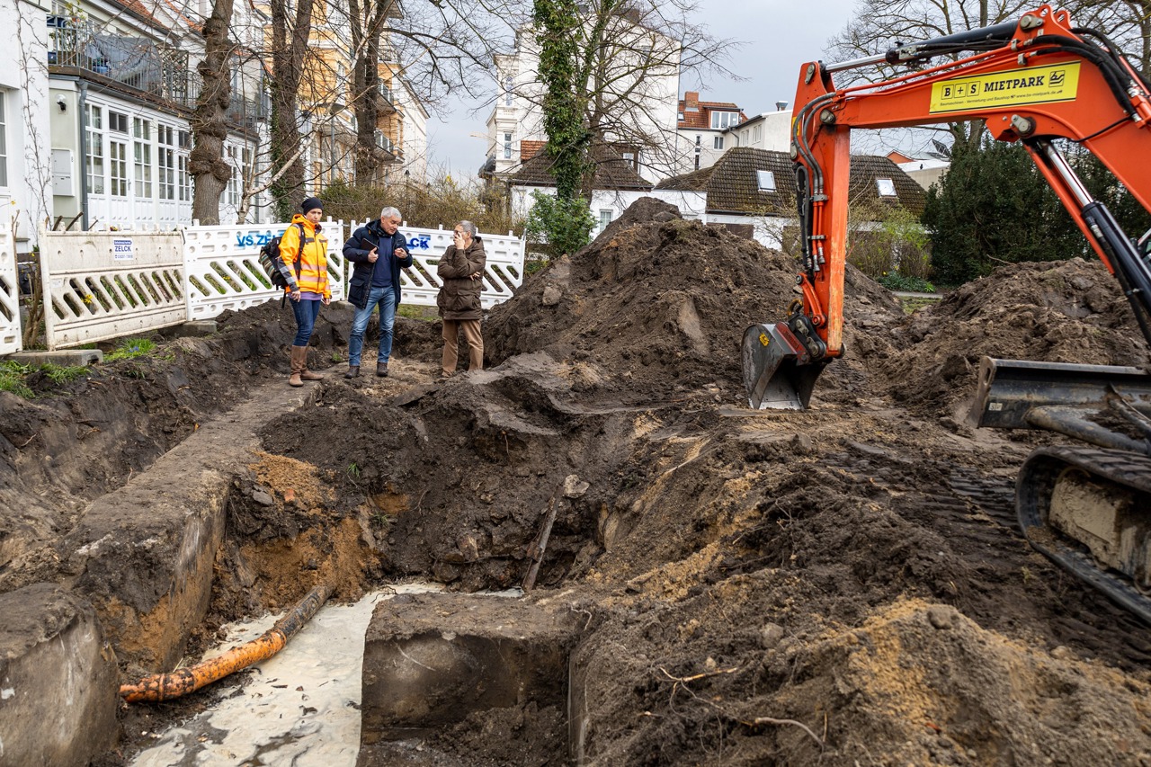 Landschaftsarchitektin Doreen Hendler (v.l.), Stefan Patzer (Sachgebietsleiter Freiraumplanung und Bau, Amt für Stadtgrün) und Stadtarchäologe Ralf Mulsow an der entdeckten Bunkeranlage in Warnemünde