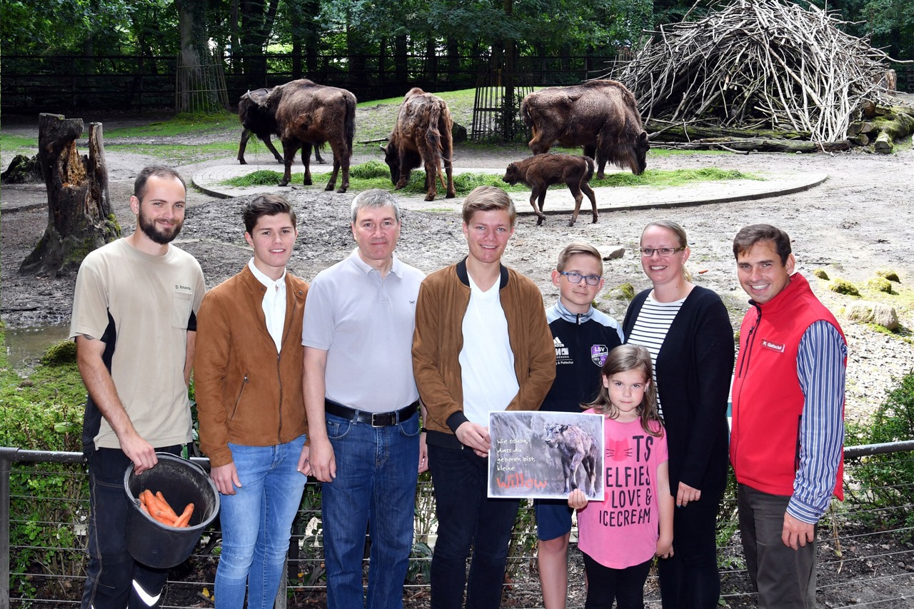 Die kleine Willow ist schon munter im Gehege unterwegs. Sie tauften die Kleine auf den Namen Willow: Tierpfleger David Kruschke (li.), Tierpate Holger Stein (3.v.li.) mit seinen Söhnen Jannick (19, 2.v.li.) und Marwin (18) sowie die Namensgeber Madeleine Schmidt (2.v.re.) mit ihren Kindern Amy (6) und Gary (12) sowie Zoo-Marketingchef René Gottschalk (re.) (Foto: Joachim Kloock)