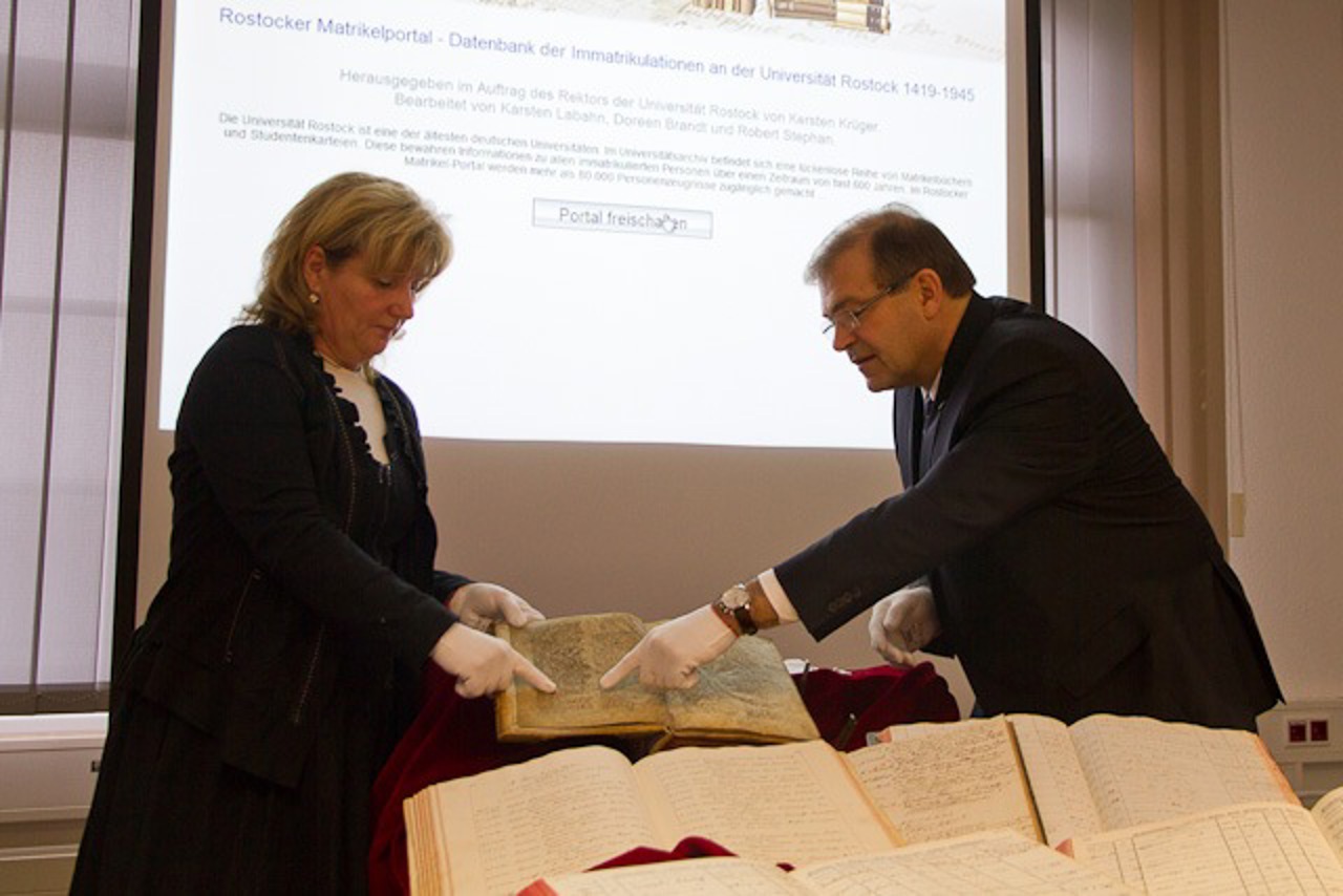 Angela Hartwig und Wolfgang Schareck mit der ältesten Matrikel der Universität Rostock