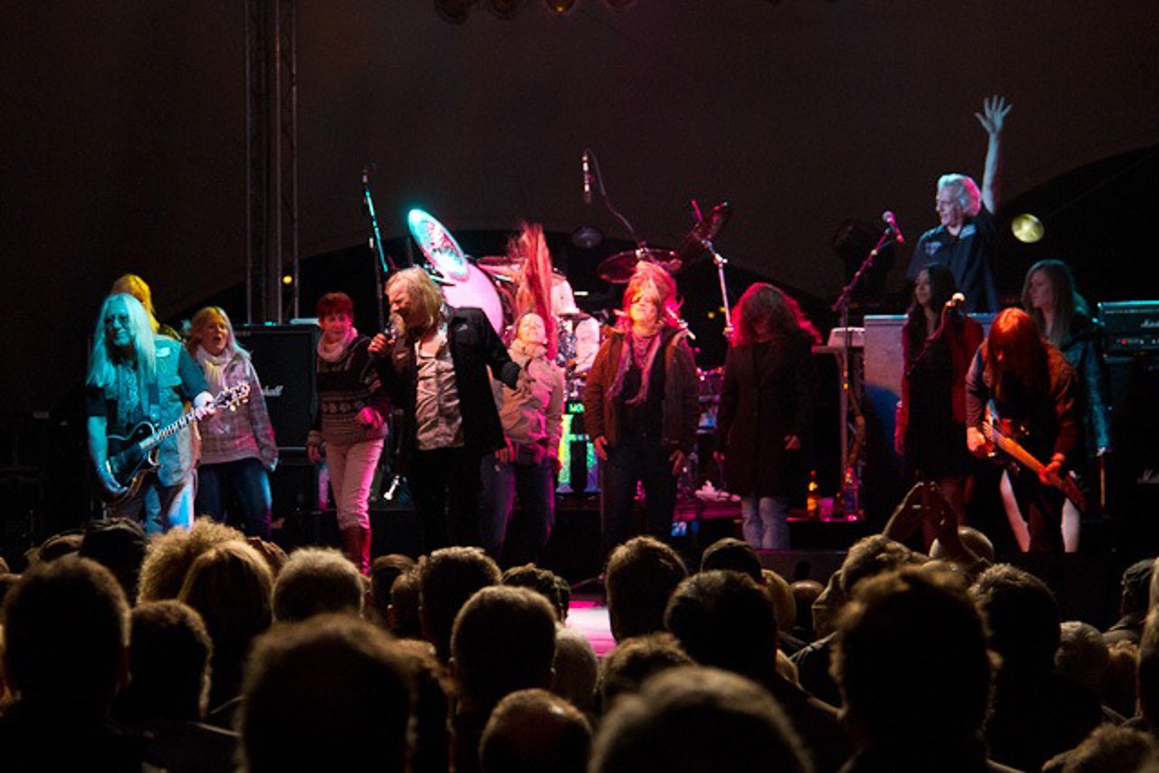 Uriah Heep headbangen mit fünf Zuschauerinnen aus dem Rostocker Publikum auf der Bühne im IGA-Park