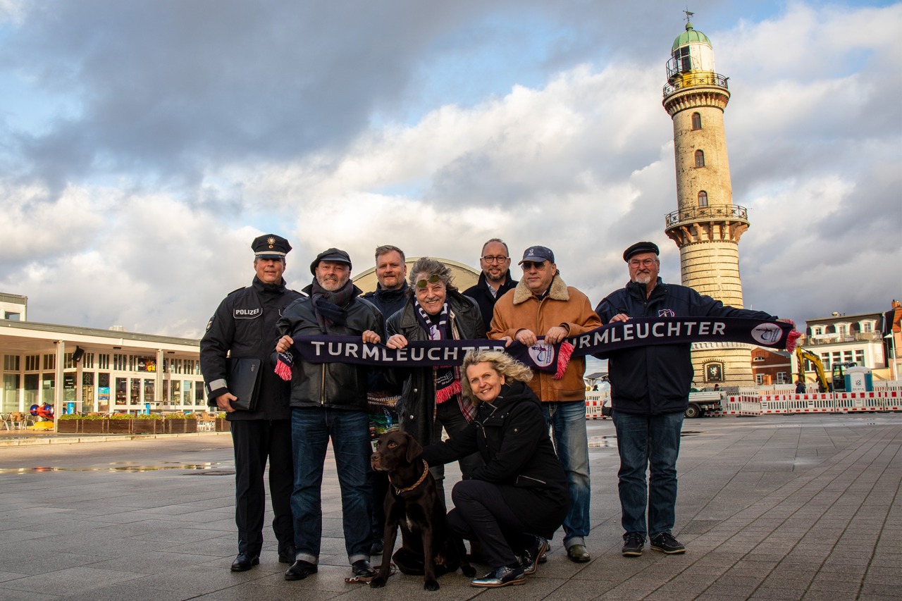 Warnemünder Turmleuchten 2020: Revierleiter Stefan Damrath (v.l.), Regisseur Torsten Sitte, Mathias Stagat (Leuchtturmverein), Dieter „Quaster“ Hertrampf, Tourismusdirektor Matthias Fromm, Jürgen Matkowitz, Leuchtturmvereinschef Klaus Möller und Organisatorin Martina Hildebrandt mit Labrador Paul freuen sich auf die Neujahrsinszenierung