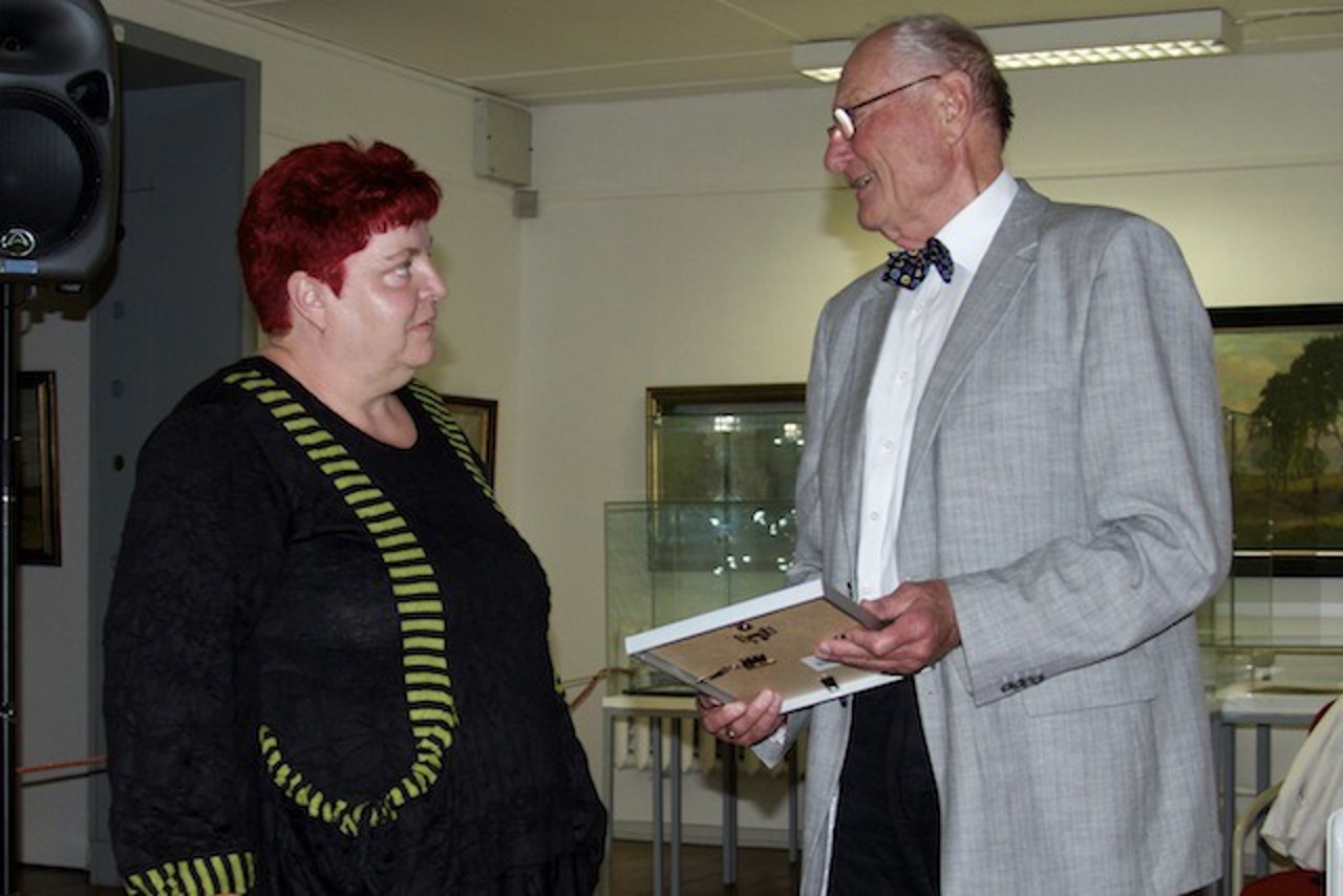 Dieter Rasch überreicht die Urkunde an den Strohhalm, die erste Rostocker Straßenzeitung