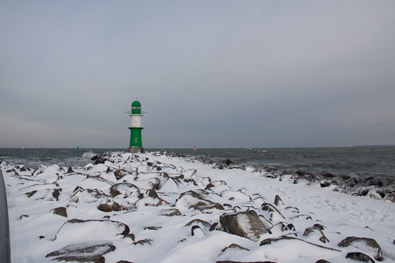 Kleiner Leuchtturm in Warnemünde und Mole im Schnee