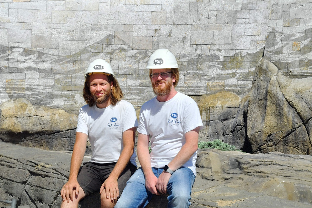 Die Dosensportler Robert Hochstaedter (links) und Jörg Schünemann vor ihrem Werk, das sie zur Abwechslung nicht mit Farbe, sondern mit Hochdruckreinigern geschaffen haben. (Foto: Zoo Rostock/Joachim Kloock)
