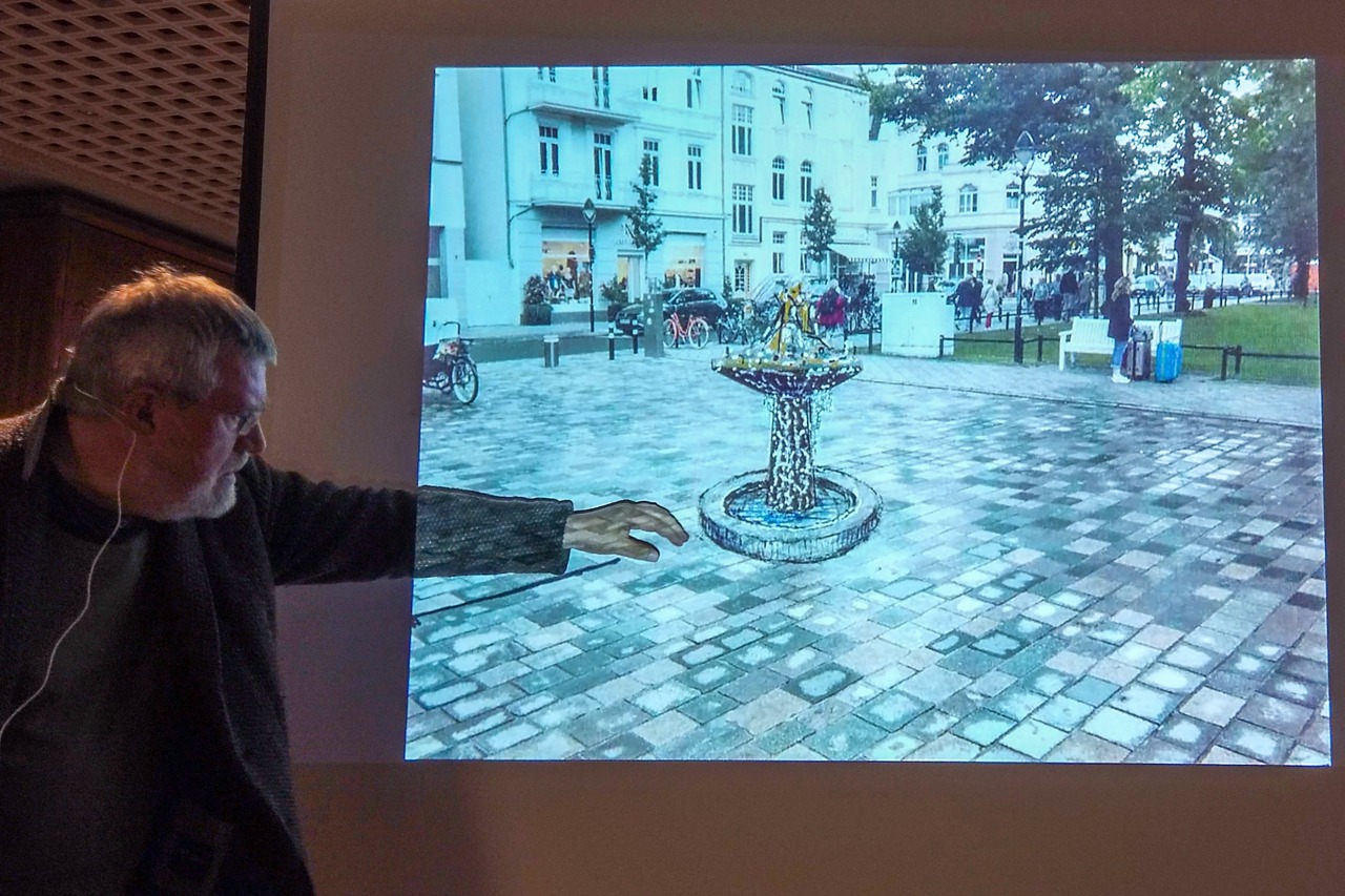 Wolfgang Friedrich erläutert seinen Brunnen-Entwurf für den Kirchenplatz Warnemünde - die endgültige Position wäre etwas weiter in Richtung Mühlenstraße