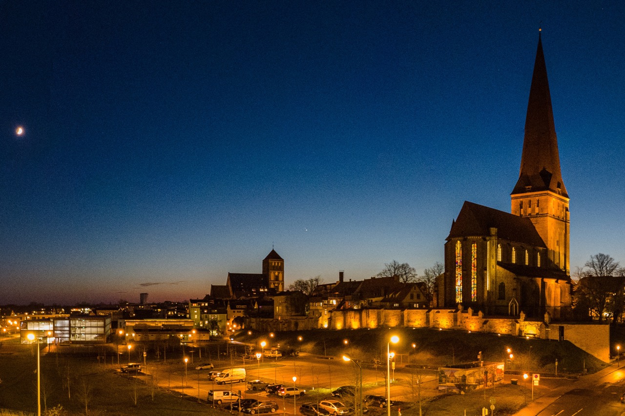 Große Konjunktion über Rostock: Links die Mondsichel, rechts oberhalb der Nikolaikirche sind sich Jupiter und Saturn bereits ganz nah