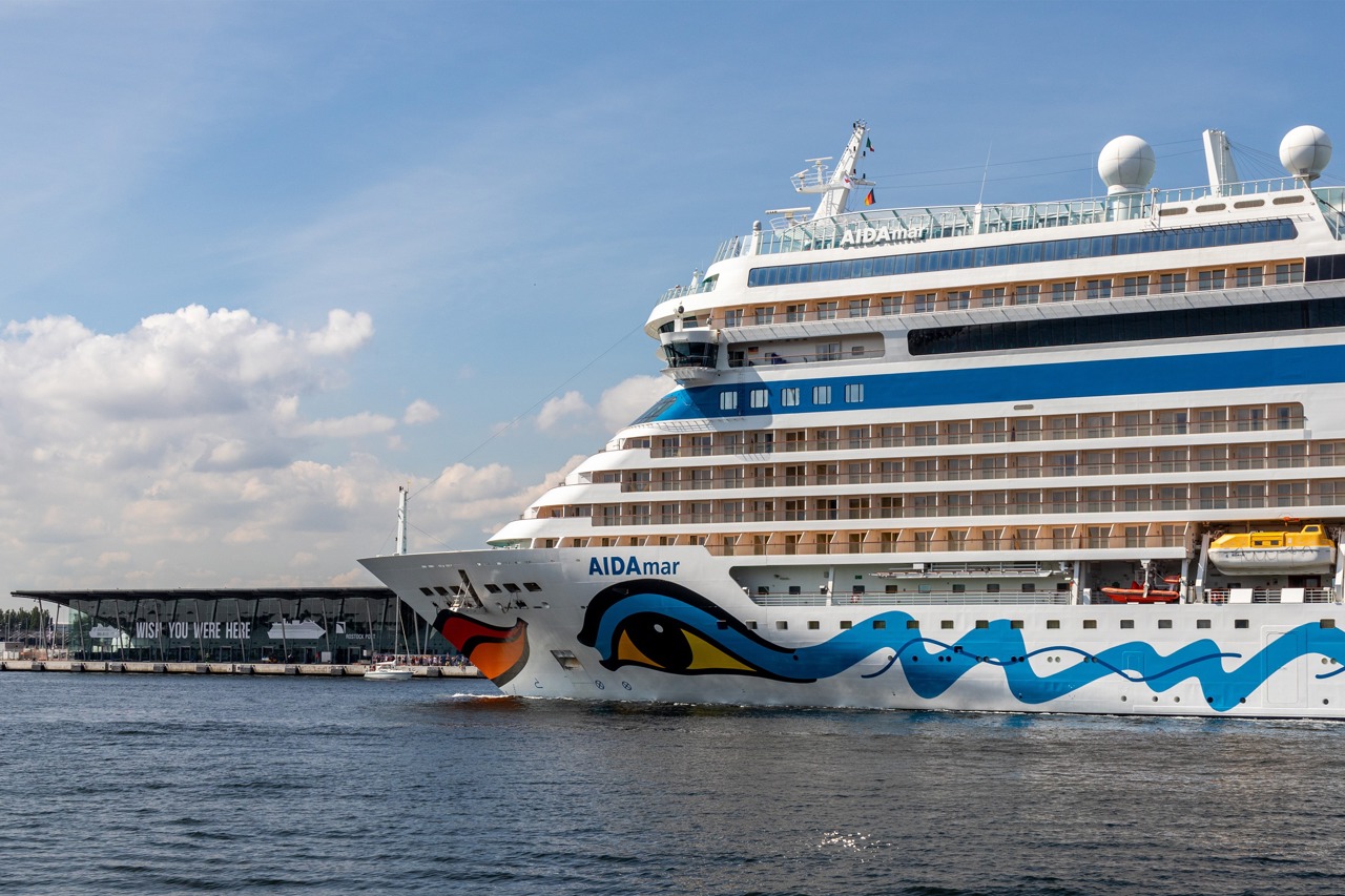 „Wish you were here“ - Das Kreuzfahrtschiff „AIDAmar“ vor dem Kreuzfahrtterminal in Warnemünde