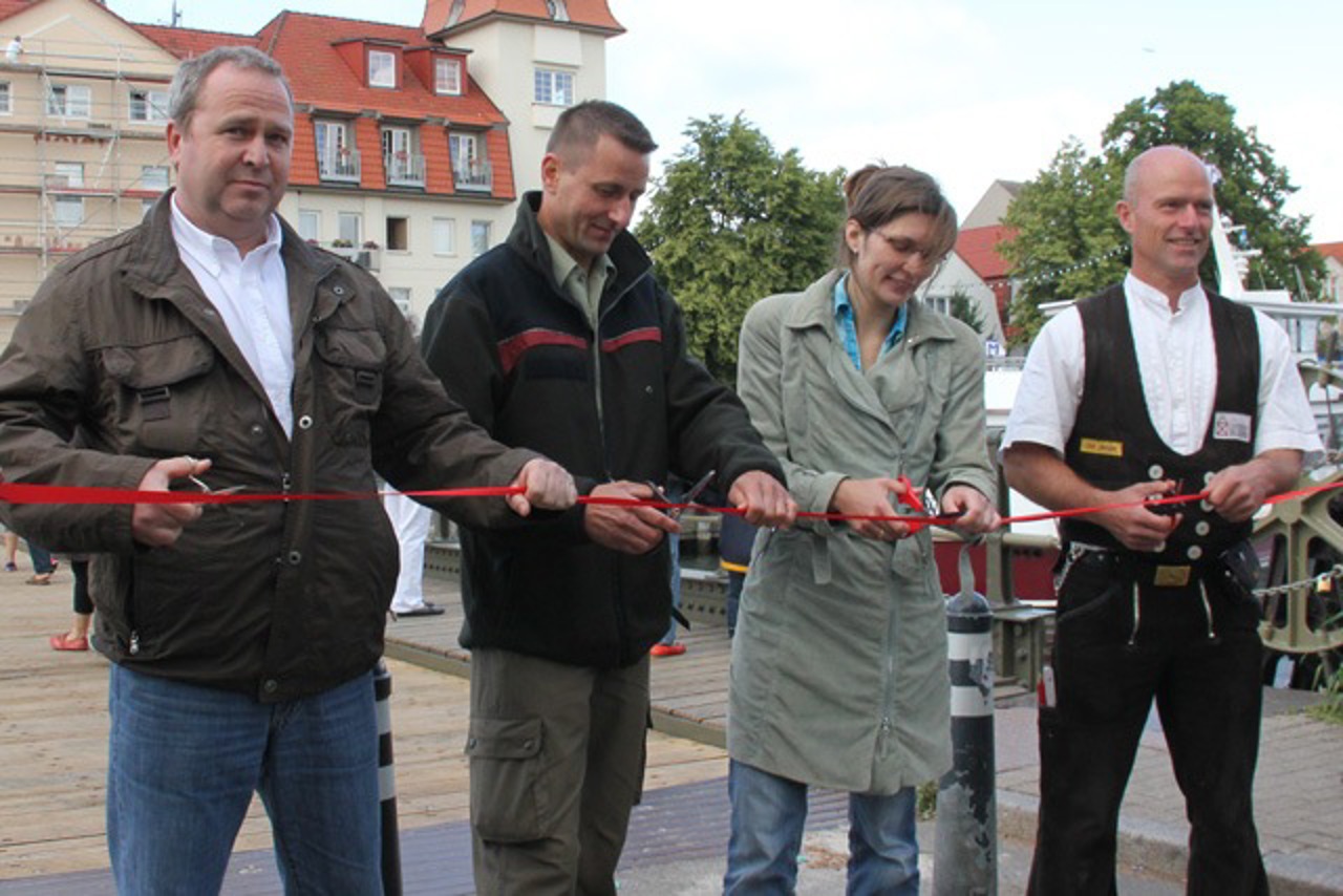 Bahnhofsbrücke Warnemünde wieder vollständig freigegeben - Steffen Frühbote (Bauleiter, Groth & Co.), Sven Ahrens (Stadtforstamt), Anja Koch (Hafen- und Tiefbauamt) und Olaf Jantzen (Zimmerei Blum)