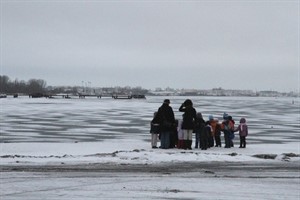 Besucher am zugefrorenen Warnowufer im Rostocker Stadthafen