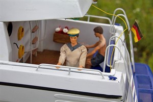 Urlauber auf einer Miniatur-Yacht