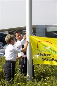 Kerstin Lange und Michael Ebert von der Polizeiinspektion Rostock befestigen das Banner