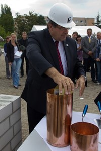 Universitätsrektor Schareck legt die besonderen Erinnerungsstücke in eine der Kartuschen