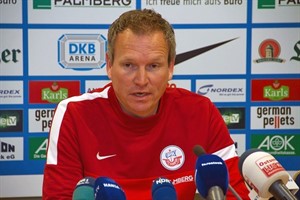 Robert Roelofsen sitzt beim Spiel Hansa Rostock Wacker Burghausen als Co-Trainert von Dirk Lottner auf der Bank