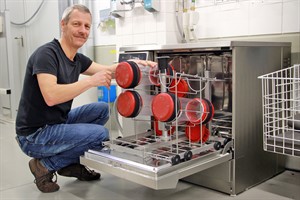 Techniker Ralf Breetzmann vor der Spülmaschine: Die Büchsen bewegen sich nach 200 Fahrten automatisch Richtung Dusche. (Foto: Unimedizin)