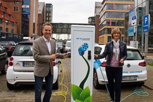 Umweltsenator Holger Matthäus und Ute Römer von den Rostocker Stadtwerken enthüllen eine Ladesäule für Elektroautos im Stadthafen Rostock