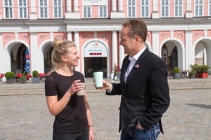 Lena Siegert und Holger Matthäus stellen das Pfandbechersystem reCup vor, das auch bald in Rostock den Plastikmüll reduzieren soll.